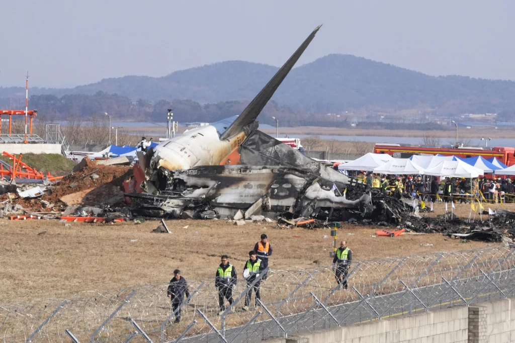 The wreckage of Jeju Air Flight 7C2216 engulfed in flames after crashing into a wall at Muan International Airport, resulting in at least 124 fatalities